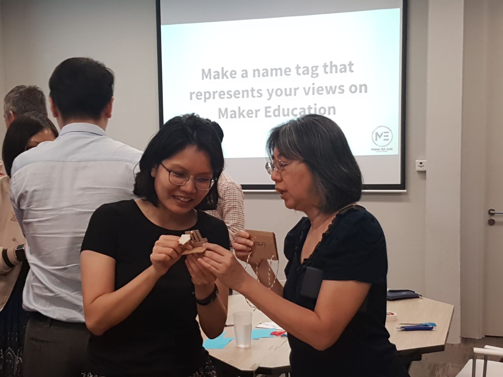 Educators at edm8ker MakerEd Meetup creating personalized name tags based on their perspective of maker education.